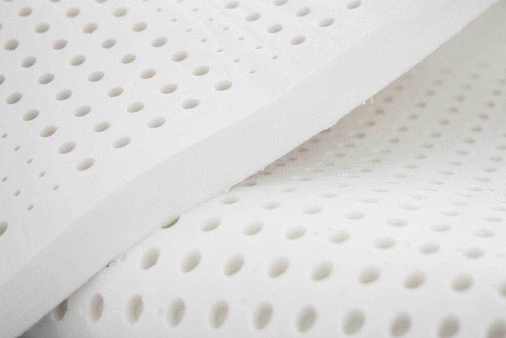 Perforated white foam sheets used in mattress design.